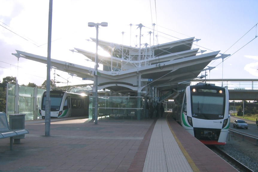Stirling train station on the Joondalup line in Perth during the daytime with trains stopped either side of the platform.