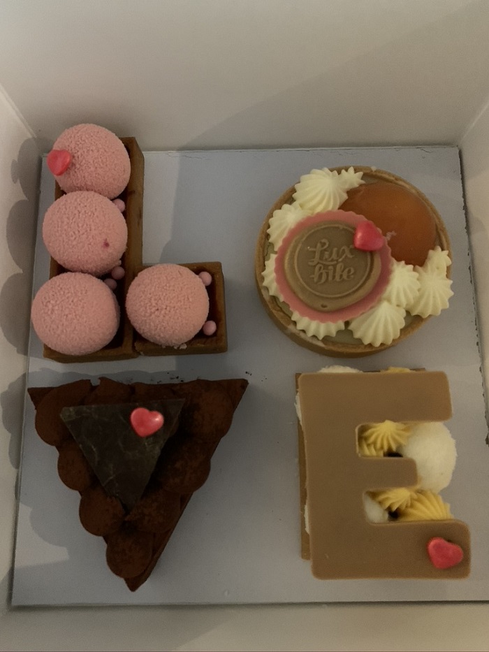A box with four small cakes that spell the word LOVE