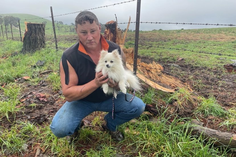 A man holds a small white dog.