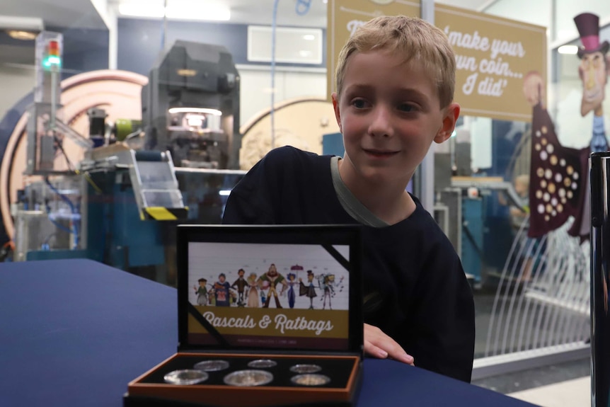 Henry Mcarthur stands behind case of winning coins at Royal Australian Mint