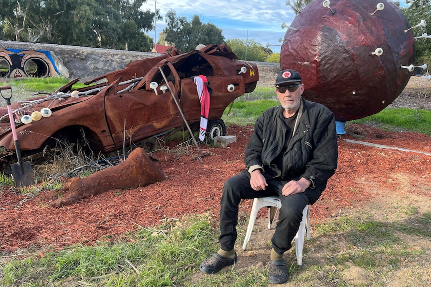 Artist Tim Burns sits with some of his art outside his York home