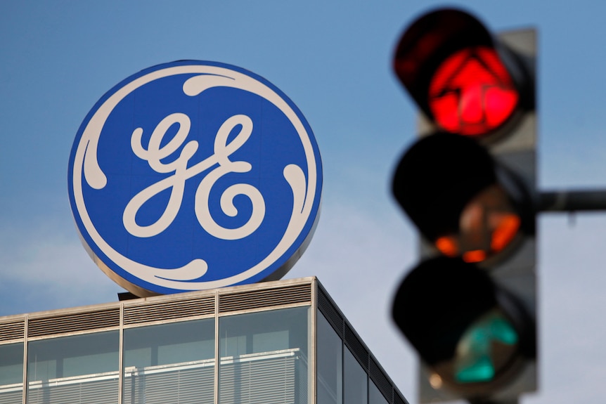 A GE Money logo on top of a building with traffic lights to the right.