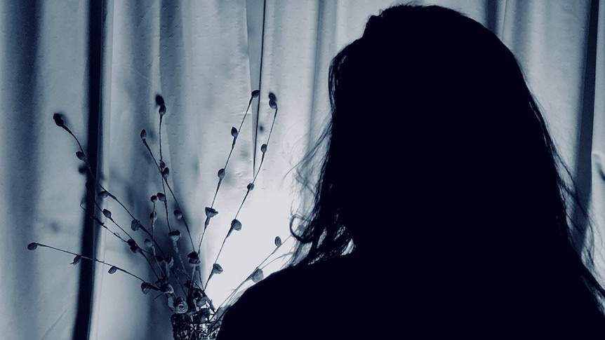 Silhouette of woman in darkness, speaking to the ABC in May 2018.