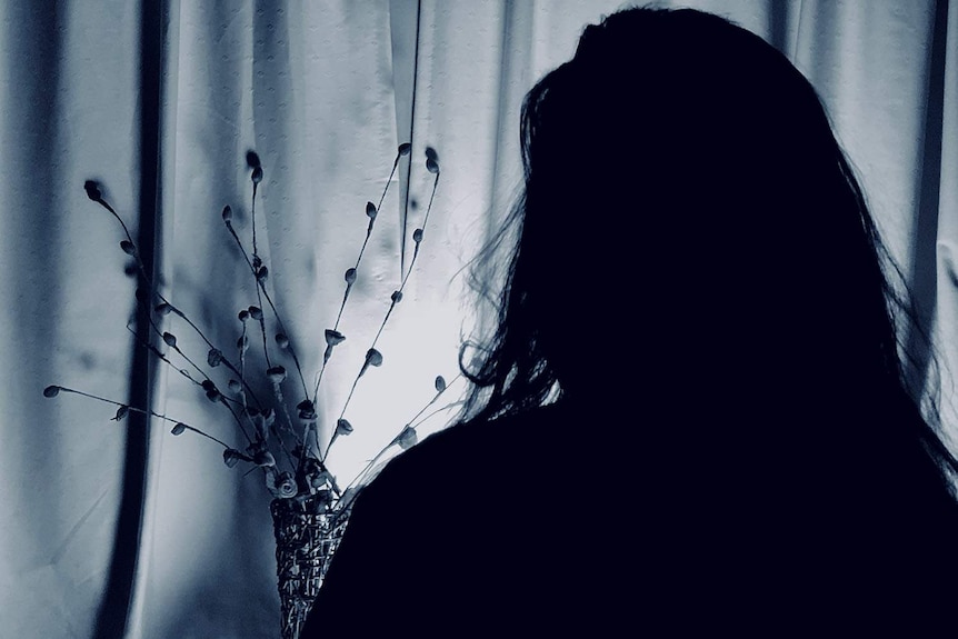 Silhouette of woman in darkness.