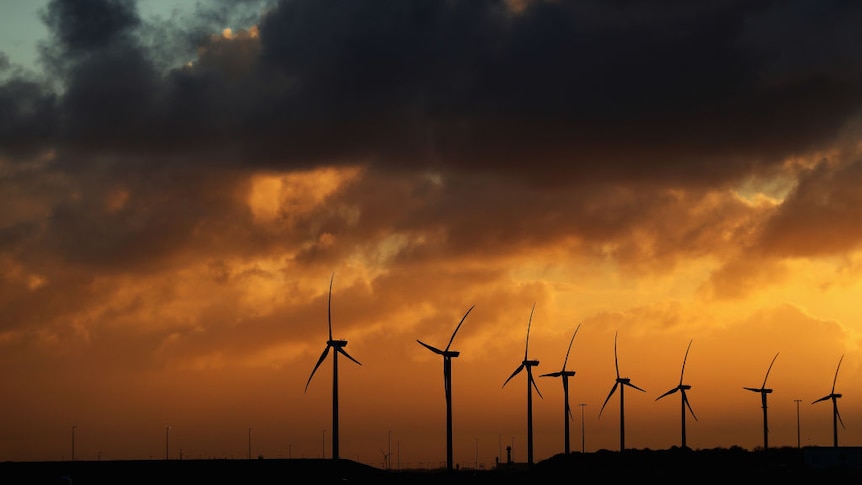 Wind turbines with an orange sky.