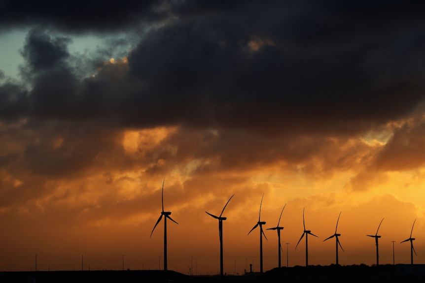 Wind turbines with an orange sky.