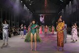 Indigenous models wear brightly coloured designs on a fashion runway in Sydney.