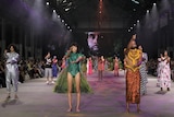 Indigenous models wear brightly coloured designs on a fashion runway in Sydney.