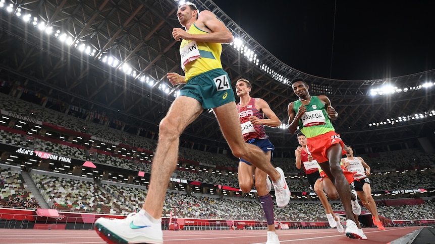 Three athletes running on a track while competing in an event 