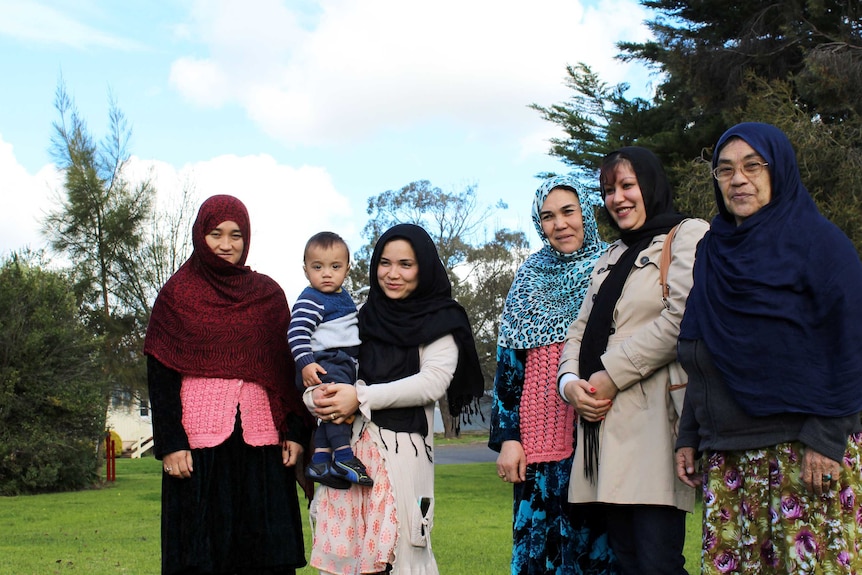 A group of Afghani migrant women standing outside.