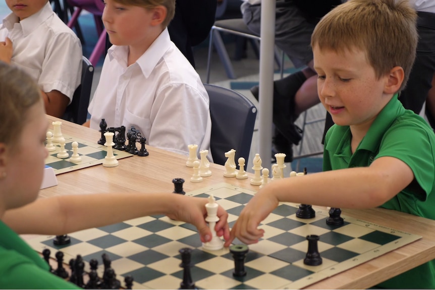 Boy playing chess with a girl