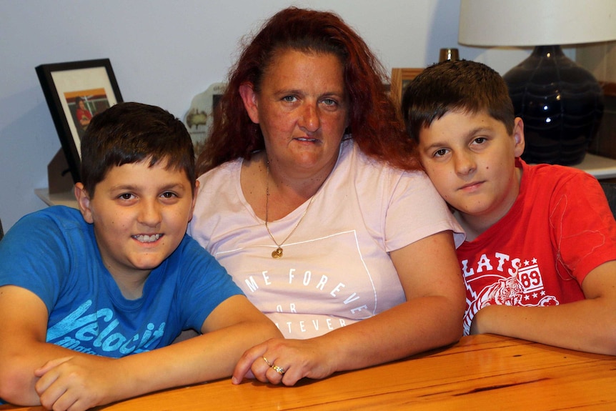 Deb sits flanked by her two sons.