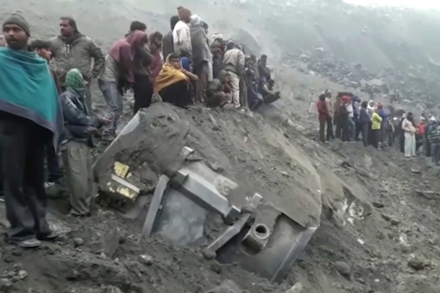 People survey the damage of a collapsed mine in India.