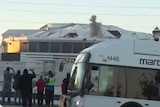 Crowds watch smoke rise from Atlanta Dome moments before implosion as bus passes between them and the camera