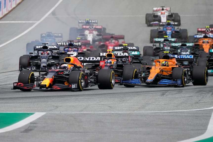 Formula One cars take the first corner of a race.