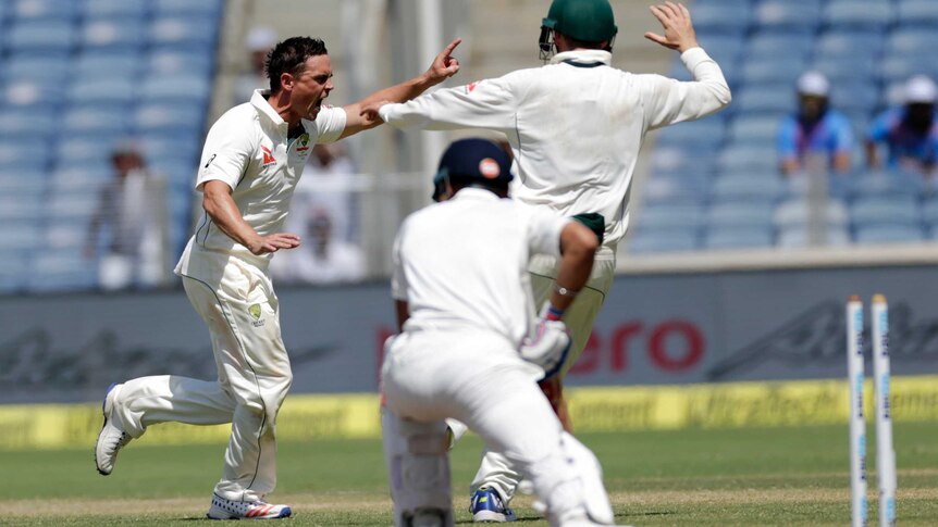 Australia's Steve O'Keefe gets India's Virat Kohli's wicket on day three of the first Test in Pune.