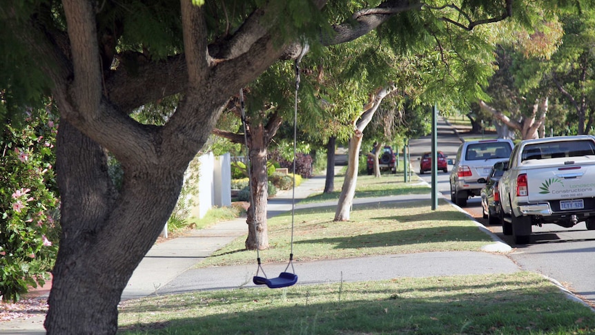 A street in Nedlands with lots of green trees and a child's swing in the foreground.