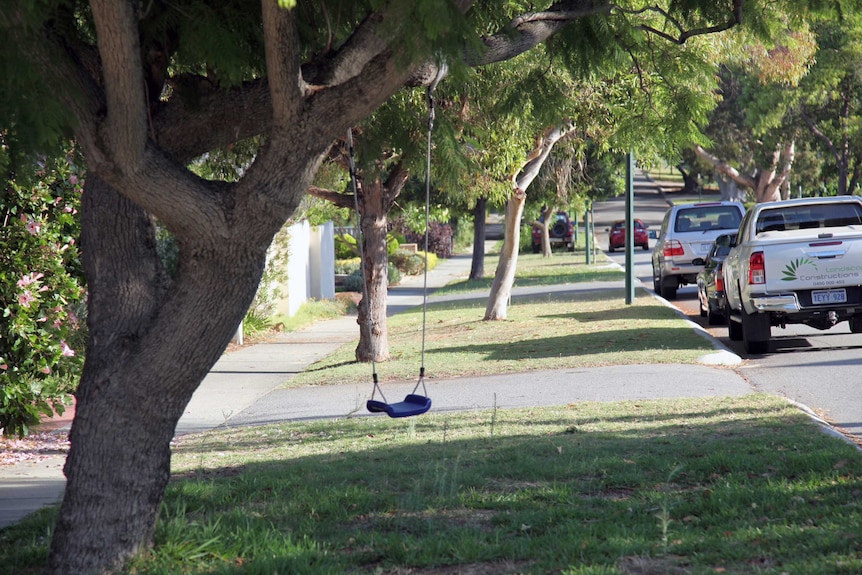 A street in Nedlands with lots of green trees and a child's swing in the foreground.