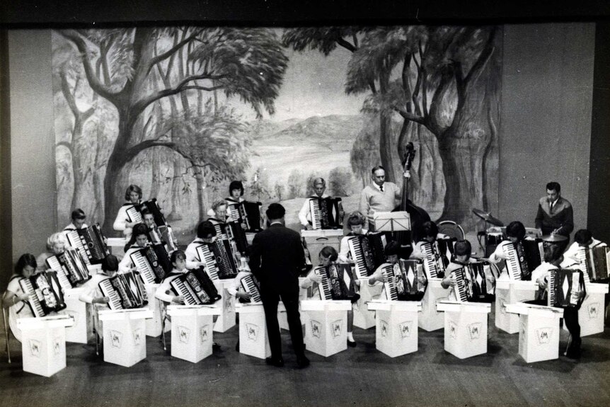 A black and white image of accordion players in a concert hall