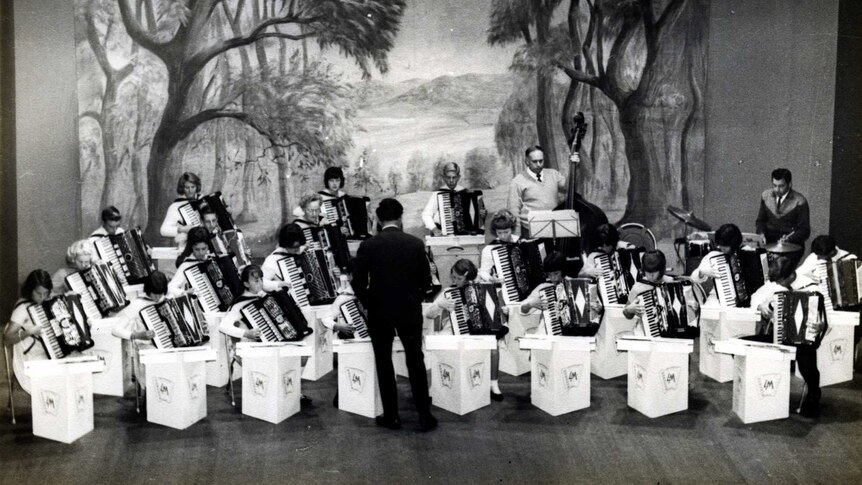 A black and white image of accordion players in a concert hall