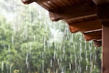 Rain falls and drips off a verandah awning.