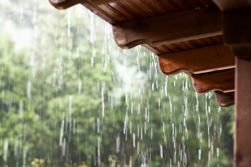 Rain falls and drips off a verandah awning.