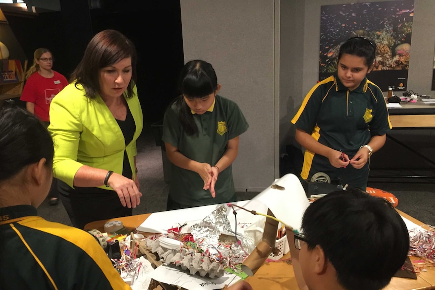 Science Minister Leeanne Enoch talks to four students busy creating projects.