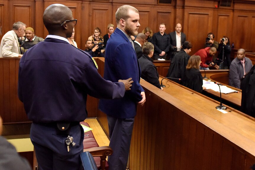 Henri van Breda, right, is led out of the High Court in Cape Town, South Africa.