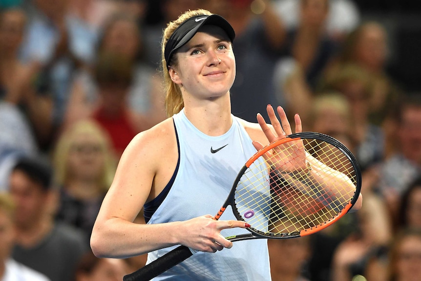 Elina Svitolina uses her racquet to clap the crowd after winning the women's final at the Brisbane International.