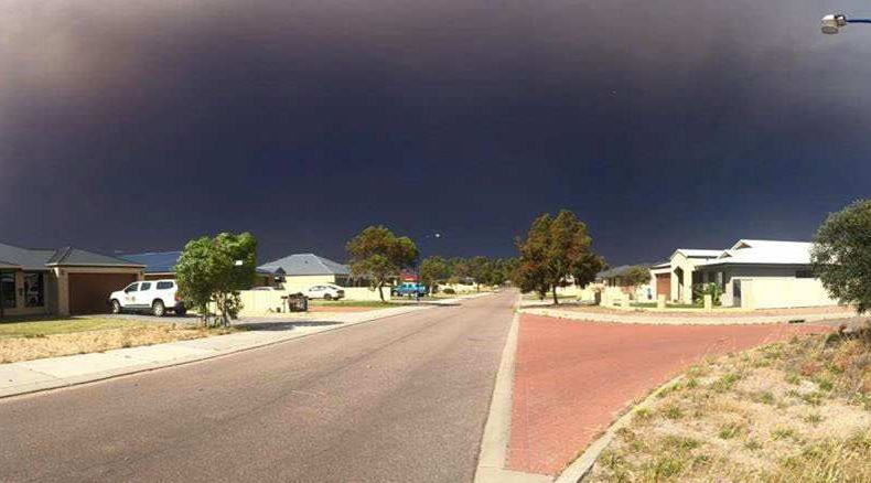 Smoke from a bushfire billows over houses in Cairns Parade in Le Grande estate in Esperance