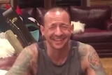 A screenshot from a Twitter video shows Chester Bennington smiling with his family.