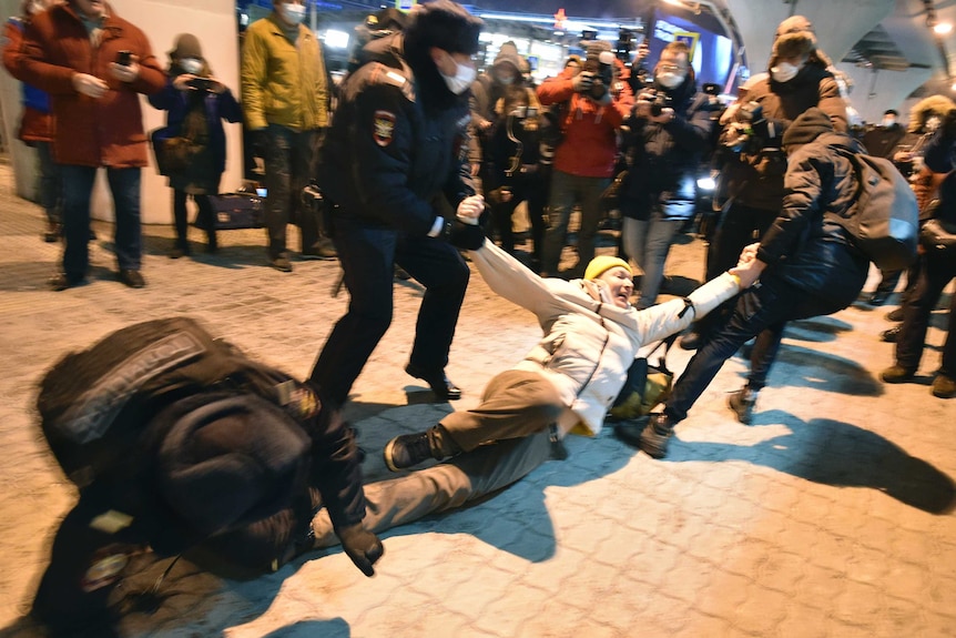 Police officers detain a man at Moscow's Vnukovo airport