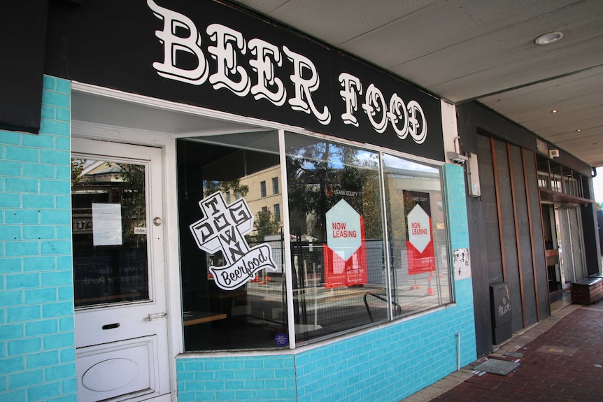 For lease signs in the windows of a bar and restaurant.