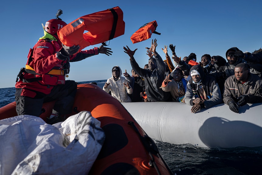 Migrants and refugees from Africa sailing adrift on an overcrowded rubber boat