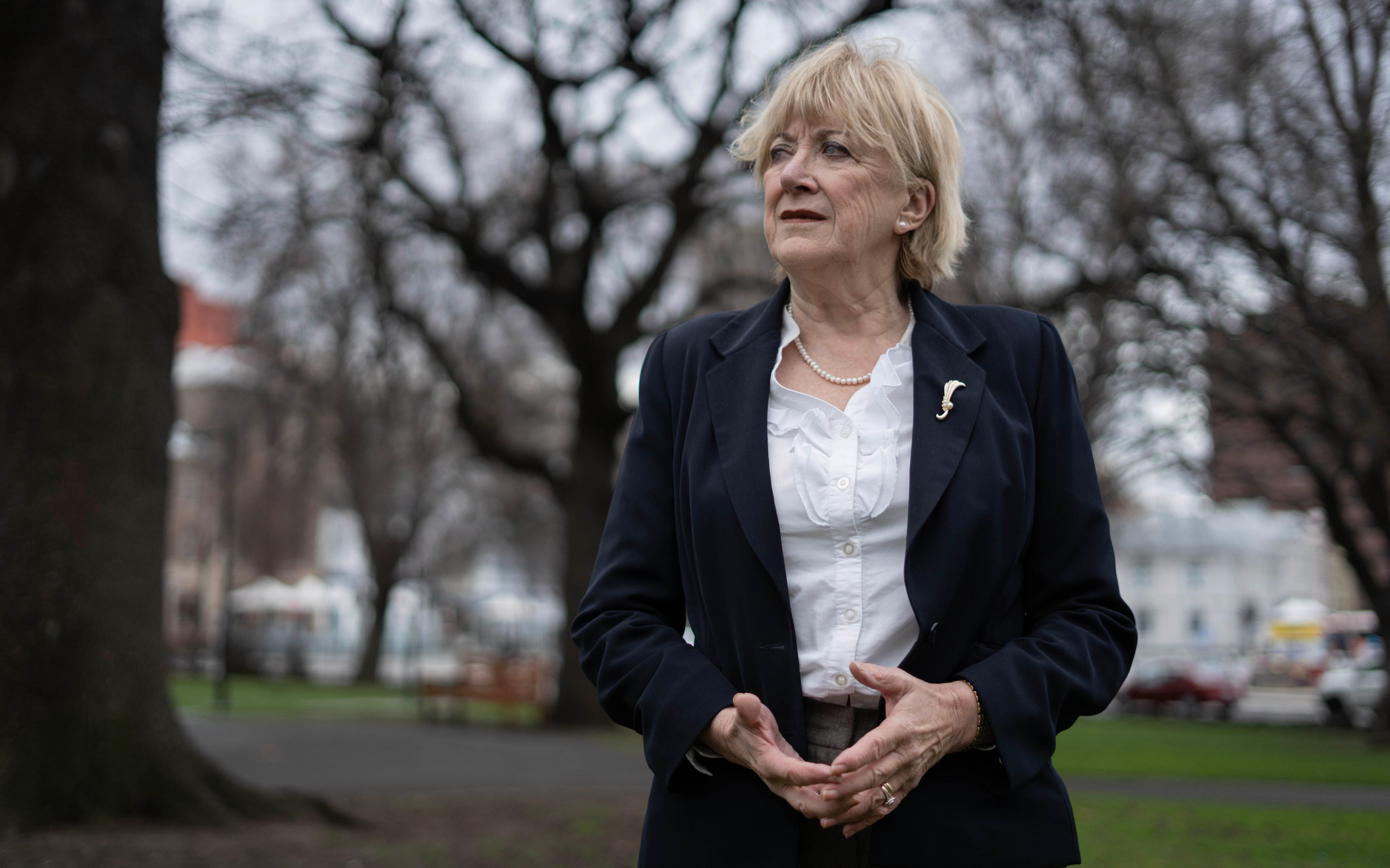 Romemary Armitage parece fuera de campo, con árboles al fondo. 