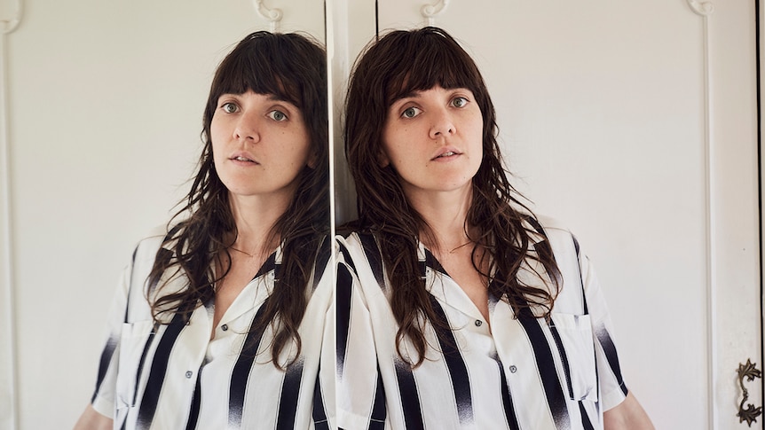 A mirror image of two Courtney Barnetts, wearing a black and white striped top.