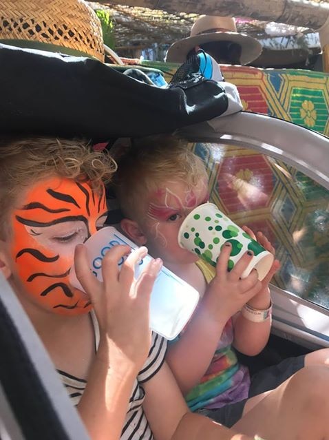 Two young boys with their faces painted enjoy a drink at the Woodford Folk Festival south-east Queensland.