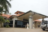 resort building with palm tree on left and four-wheel-drive on right