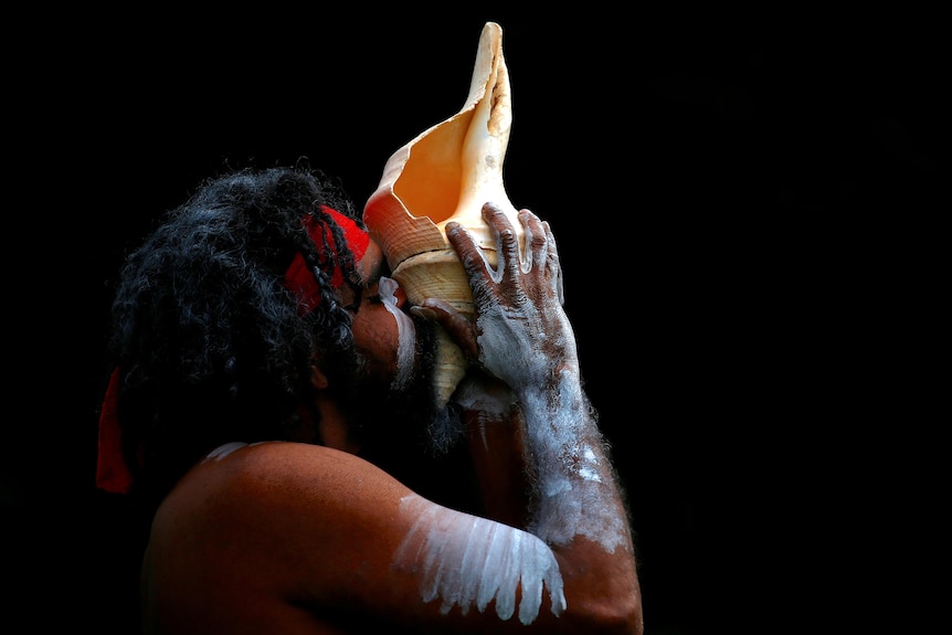在一次仪式上，一名原住民男子从海螺中喝水