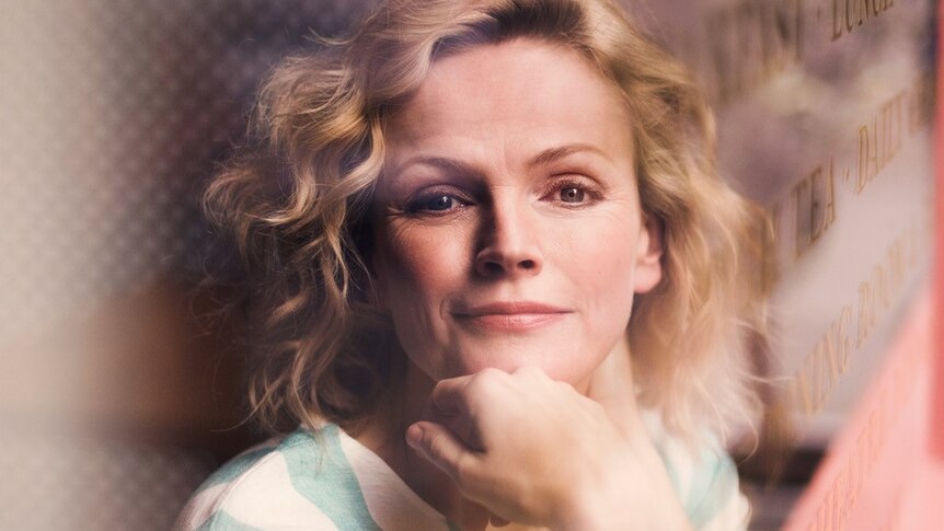 Maxine Peake seen through the front window of a restaurant.