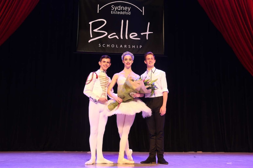 Joshua Price, Lania Atkins, Harrison Lee stand on stage.