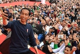 Indonesia's president Joko Widodo takes a selfie in front of a huge crowd