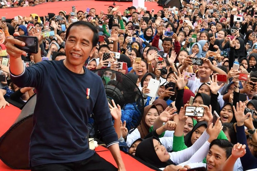 Indonesia's president Joko Widodo takes a selfie in front of a huge crowd