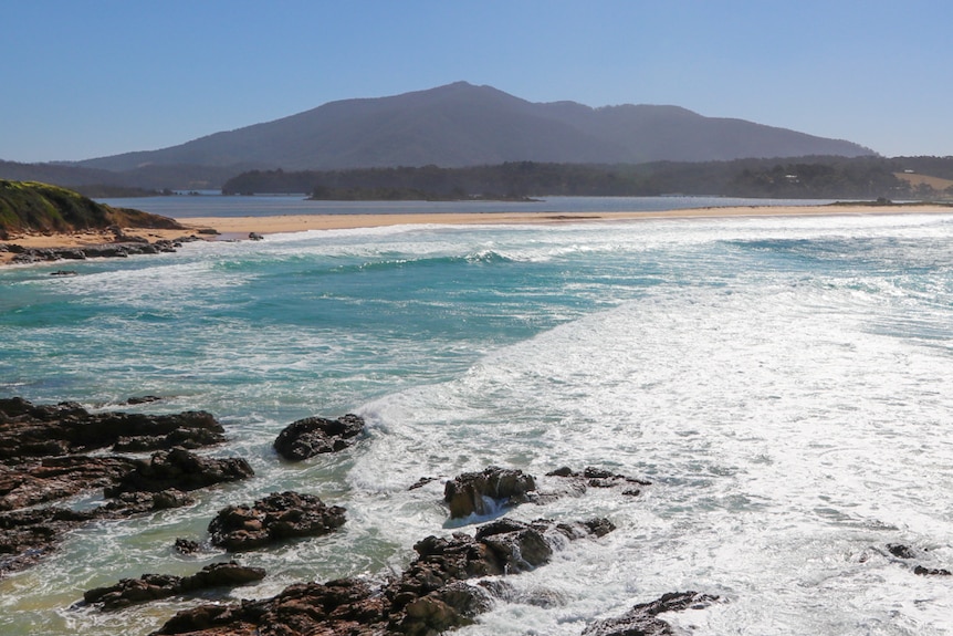 View of Mount Gulaga from across a sparkling ocean