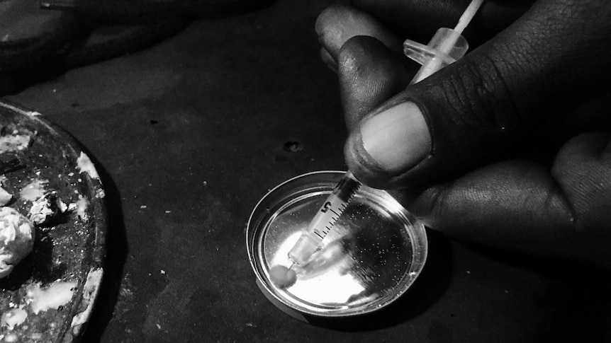 A powdered drug is drawn off a metal plate into a syringe.