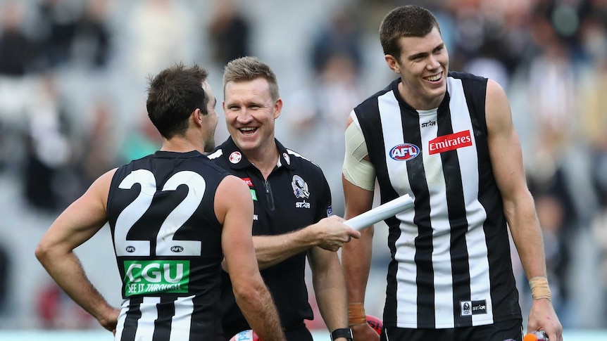Steele Sidebottom, Nathan Buckley and Mason Cox of Collingwood have a laugh after the win over Geelong.