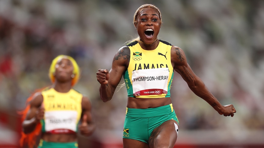 A Jamaican female sprinter celebrates after crossing the finish line to win gold at the Tokyo Olympics.