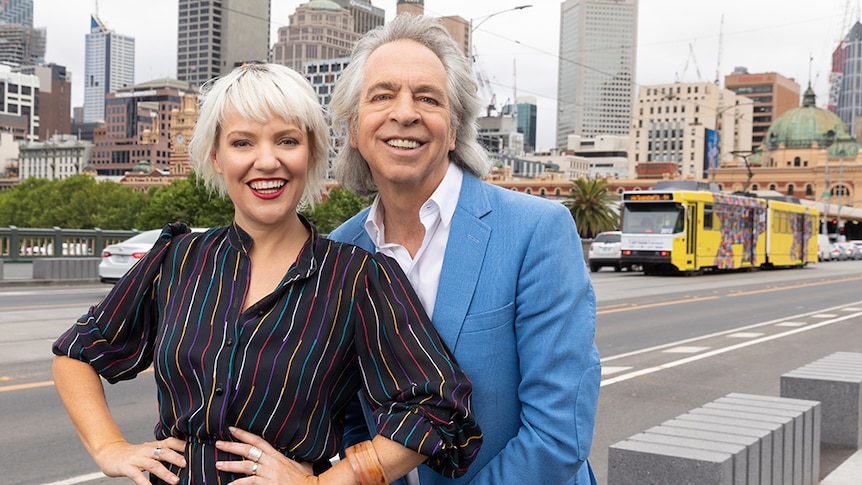 A portrait of ABC presenters Jacinta Parsons and Brian Nankervis with a Melbourne tram in the background.