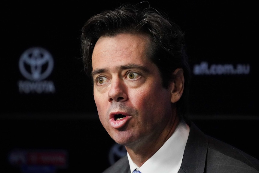 An AFL executive in a suit speaks at a press conference.