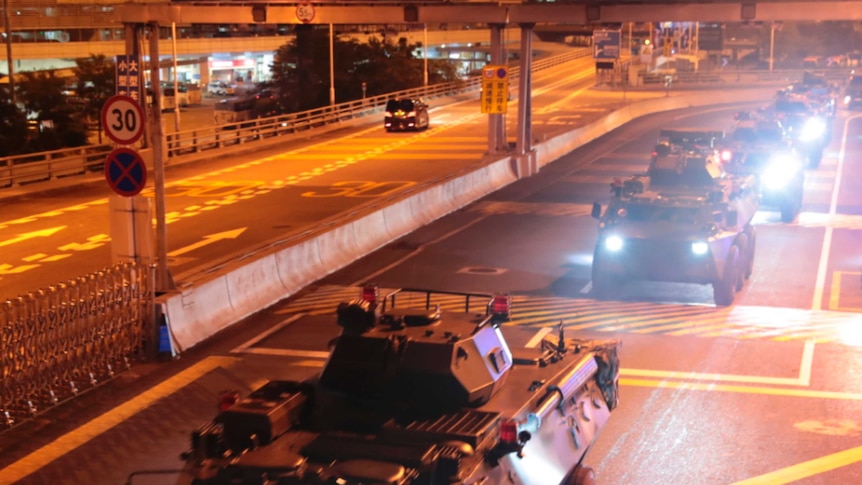 Armored personnel carriers of China's People's Liberation Army drive down a highway.